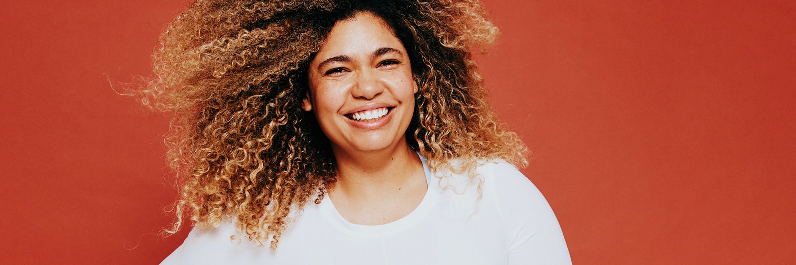 Smiling plus size fitness model with curly hair